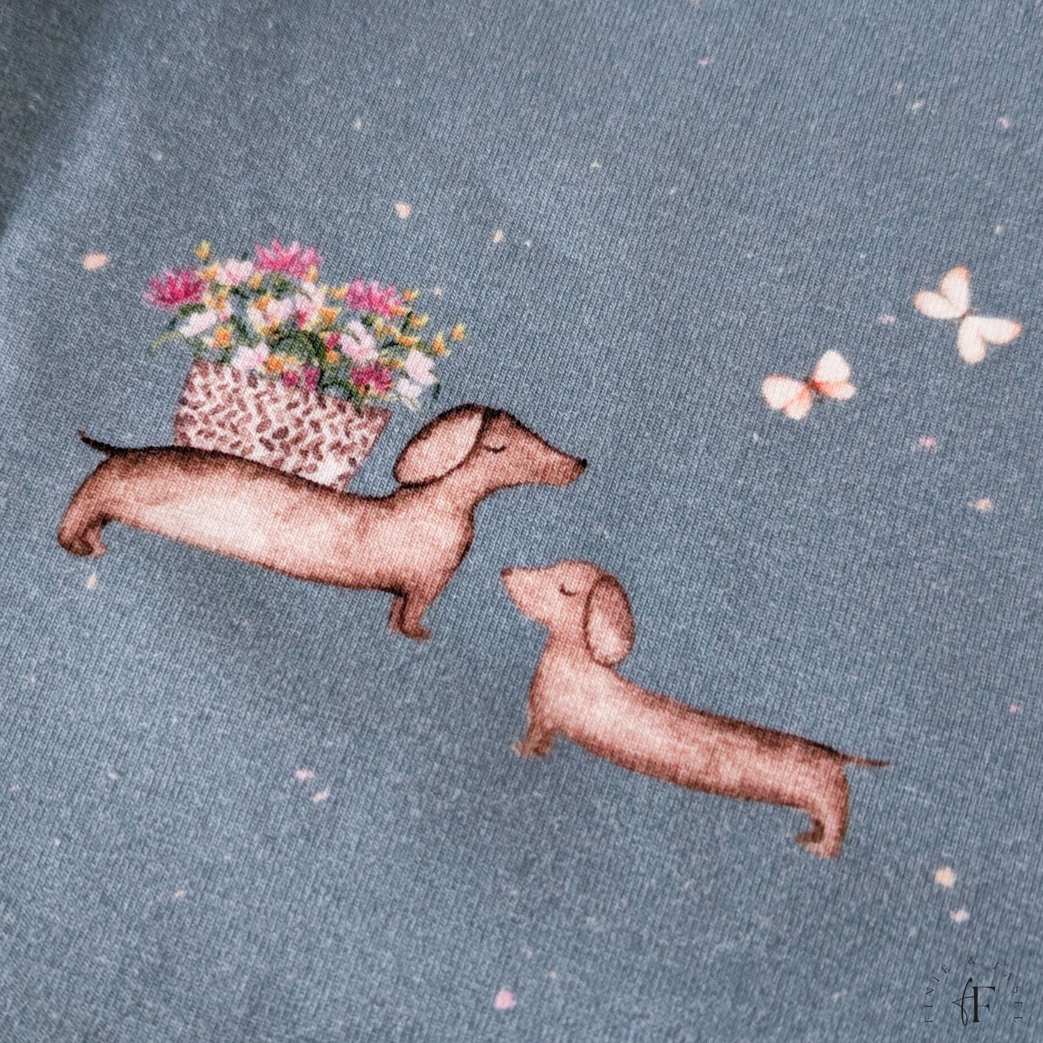 Aquarell-Dackel mit Blumenkranz auf Jersey-Stoff Blumendackel blau – liebevoll illustriertes Design, exklusiv bei Finie & Fasel
