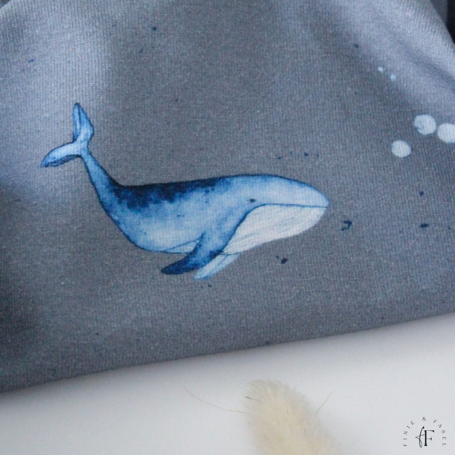 Nahaufnahme eines Aquarellwals auf blauem French Terry Jersey – exklusives Design von Finie & Fasel