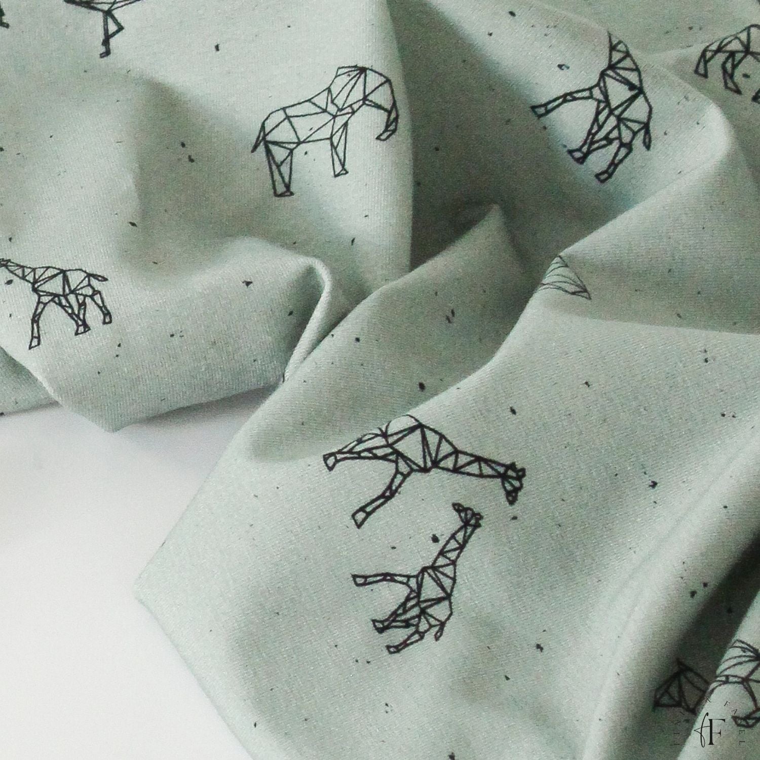 Detailansicht des mintfarbenen Jersey Stoffs mit schwarzen Line-Art Giraffen und Elefanten