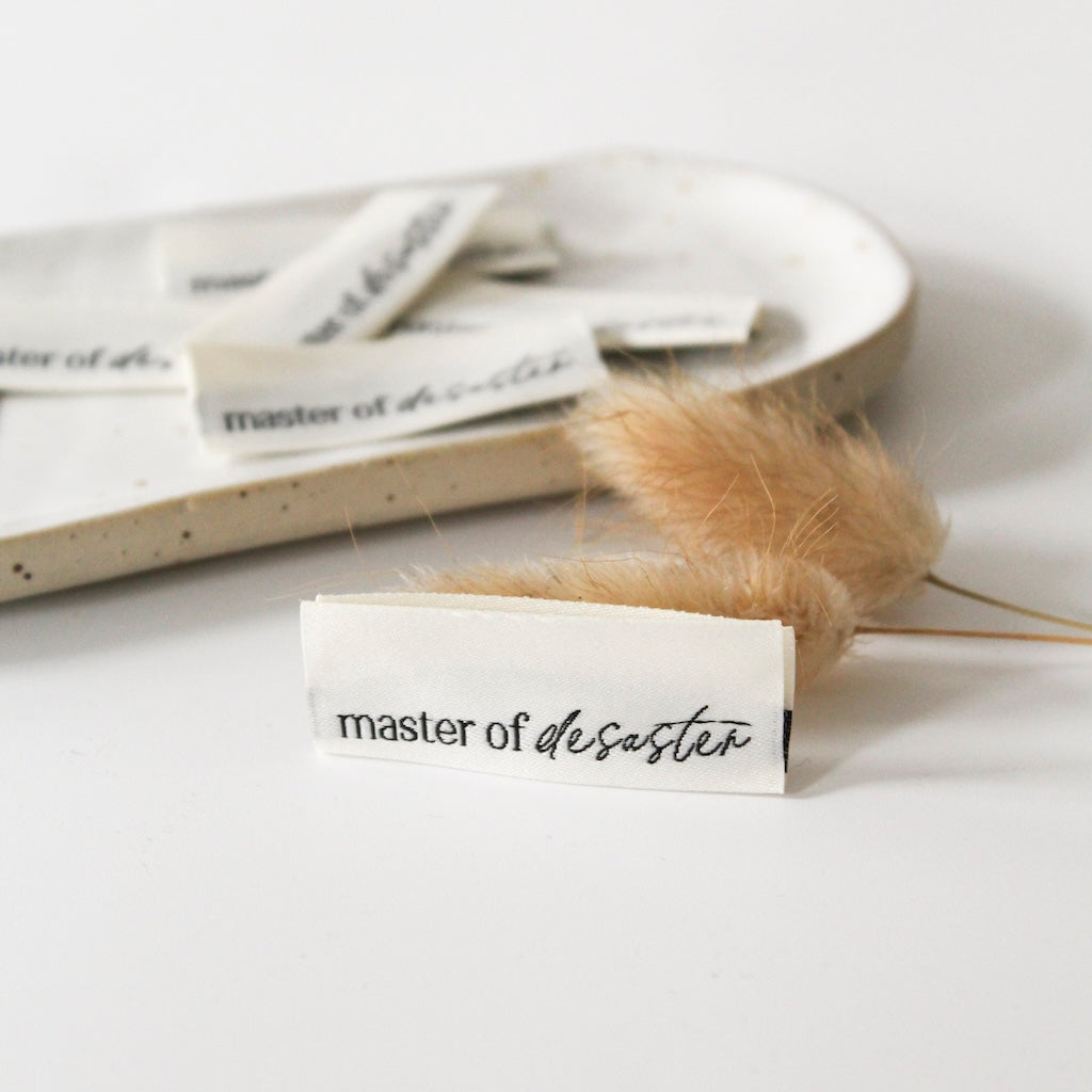 Weblabel mit Aufschrift „master of desaster“ – Einnählabel für Kleidung